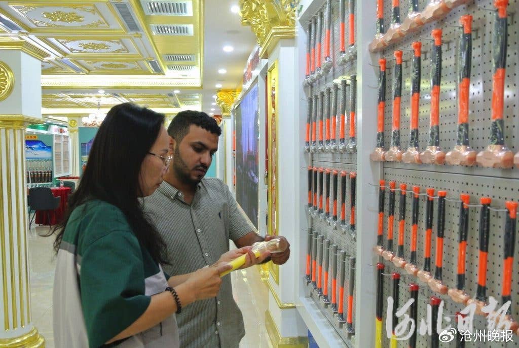 8月11日，在河北中泊防爆工具集团股份有限公司科创成果展览馆，工作人员（左）向外国客户介绍一款防爆锤